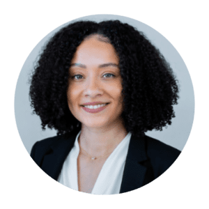 A woman with black curly hair smiling for a picture