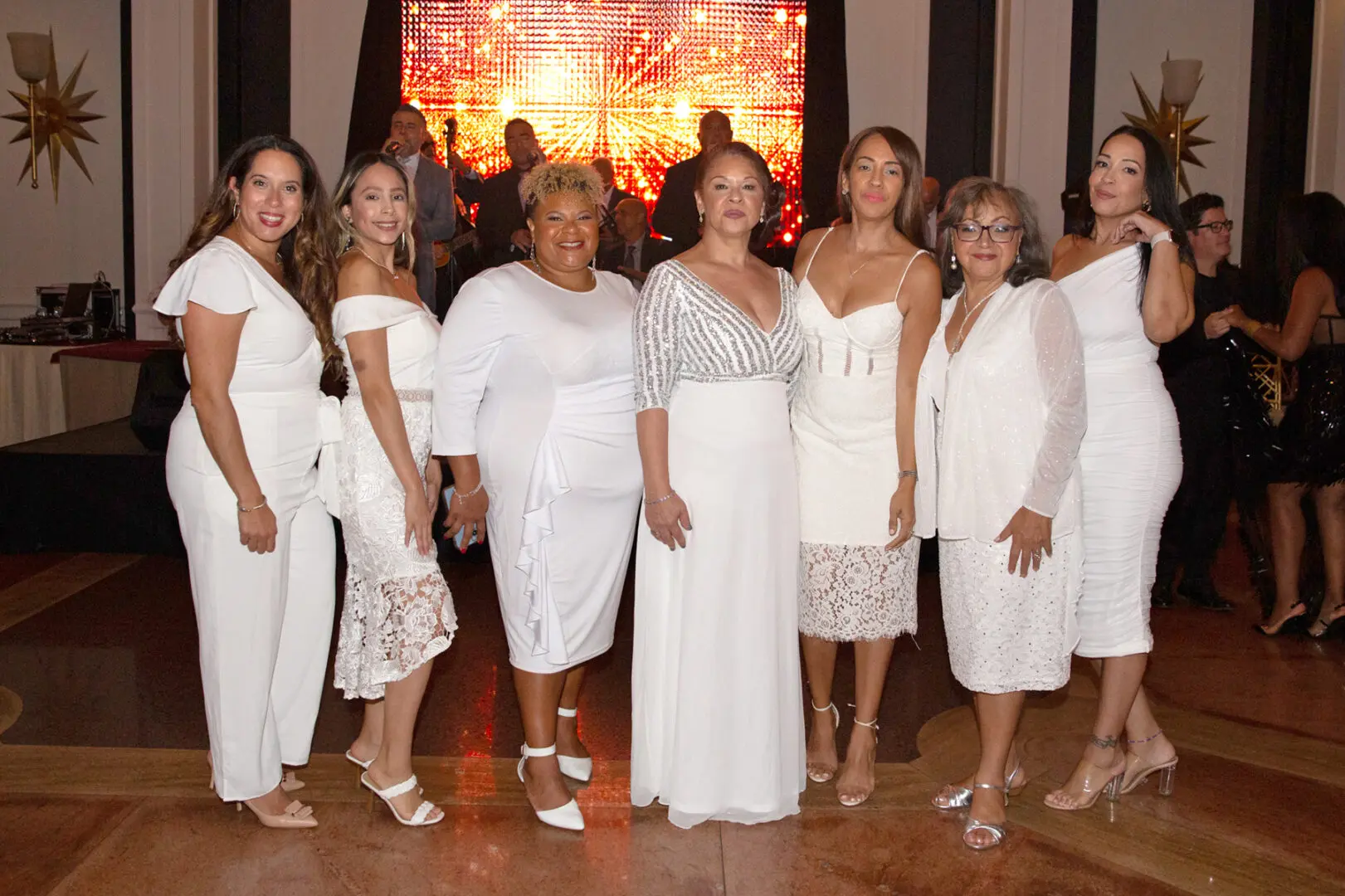 A group of women wearing white dress at an event
